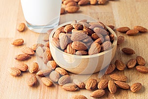 Almond seeds in a bowl wood and  milk glass on table wooden