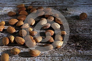 Almond unshelled, badam, handful forest fruit harvest on wood