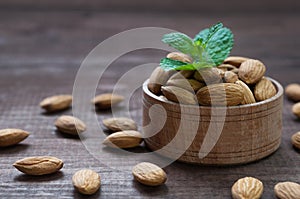 Almond in a wooden bowl with mint leaves