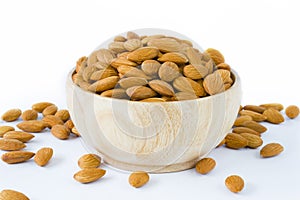 Almond in wooden bowl on white background isolated.
