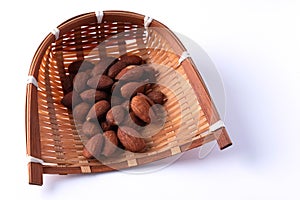 Almonds in bamboo basket on white background