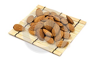 Almonds on a bamboo, on a white background.