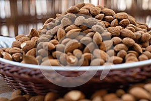 Almonds, in a basket, on a wooden table.