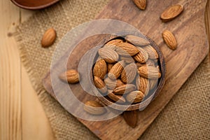 Almonds In Bowl on wood table background with copy space.top view