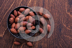 Almonds in bowl on wooden table