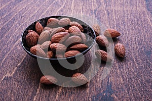 Almonds in bowl on wooden table