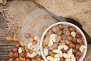 Almonds, cashew and hazelnuts in ceramic bowl on a rustic wooden