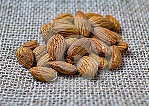 Almonds in detail. Handful or portion of almonds on jute fabric photo