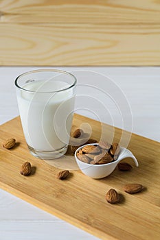 almonds and glass with almond milk on wooden background