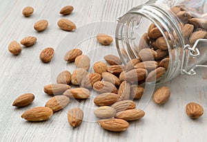 Almonds, nuts. Almond kernels are poured out of a glass jar, which lies on a light table