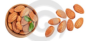 Almonds nuts with leaves in wooden bowl isolated on white background with  full depth of field. Top view. Flat lay.