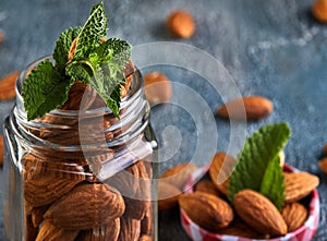 Almonds in a transparent jar with sheets of mint on the top