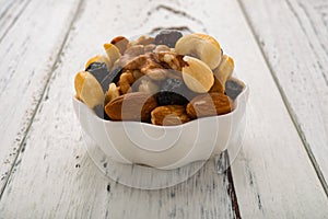 Almonds and walnuts and cashew nuts and raisin and dry blueberries on white dish