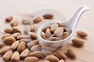 Almonds on a white background, or on a plain wooden table.