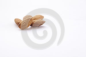 Almonds on a white background, or on a plain wooden table.