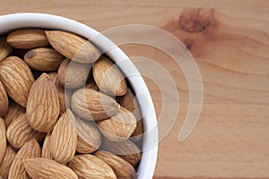 Almonds on a white background, or on a plain wooden table.