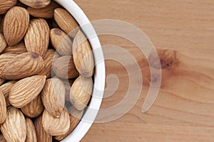 Almonds on a white background, or on a plain wooden table.