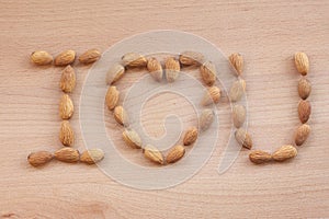 Almonds on a white background, or on a plain wooden table.