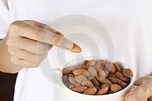 Almonds on a white background, or on a plain wooden table.