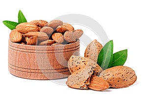 Almonds in a wooden bowl with leaves isolated on white background