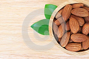 Almonds in wooden bowl on wood table