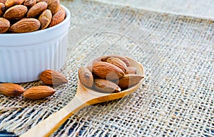 Almonds in wooden spoon on hemp