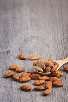 Almonds on wooden table with wood spoon photo
