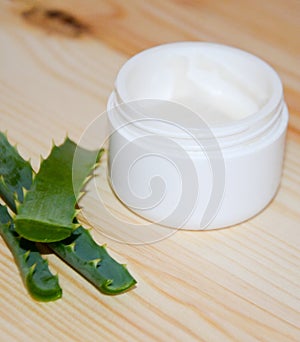 Aloaceae leaves next to a jar of cream open on