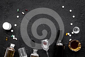 Alocohol abuse and alcoholism treatment concept. Glasses, bottles and medcine pills on black background top view copy