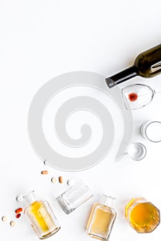 Alocohol abuse and alcoholism treatment concept. Glasses, bottles and medcine pills on white background top view copy