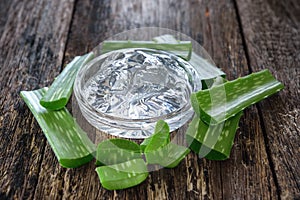Aloe vera gel in bowl with on wooden table photo