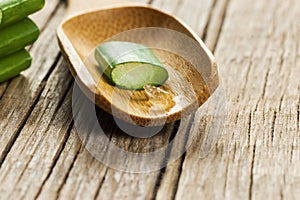 Aloe Vera gel close up. Sliced Aloevera leaf and gel with wooden spoon