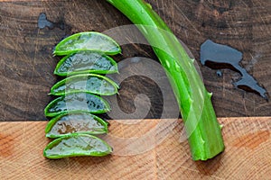 Aloe Vera leaf cut and sliced and stacked on wooden butcher block