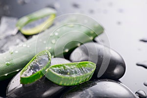 Aloe Vera slices and spa stones closeup. Aloevera plant leaf gel, natural organic renewal cosmetics, alternative medicine. Skincar