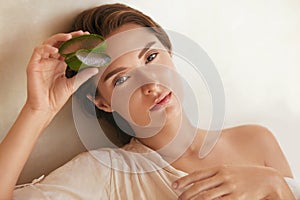 Aloe Vera. Woman Holding Slices Of Leaf And Looking At Camera. Beauty Portrait Of Tender Model With Natural Makeup.