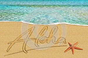Aloha written in the sand on the beach