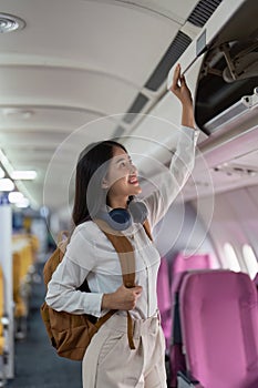 Alone Asian woman passenger traveling by plane. happy traveler on board. Solo travel concept