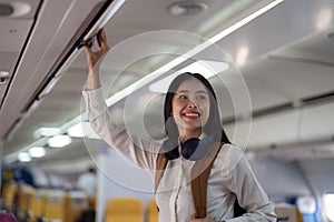 Alone Asian woman passenger traveling by plane. happy traveler on board. Solo travel concept