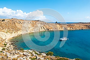 Alone boat anchored in small rocky bay near Lindos Rhodes, Greece