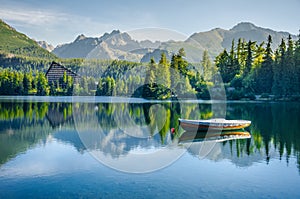 Alone Boat on empty Mountain lake Strbske pleso in National Park High Tatra, Slovakia, Europe. Original wallpaper with soft colors