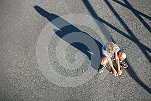 Alone boy without friends sits on skateboard. Child loneliness c