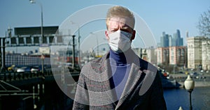 Alone city dweller is walking on street, wearing protective mask on face from viruses