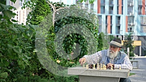 Alone elderly male playing chess with himself