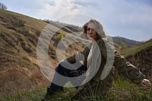 Alone girl is sad on nature hills background. Young woman  outdoor, post apocalyptic, epidemic, home violence