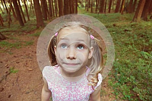 Alone little girl is afraid in dark forest. Closeup