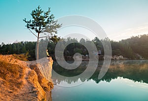 Alone man sitting alone at sunset near the sea, relaxing and thinking about the meaning of life. Hiker on top of a