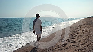 Alone man is strolling on seacoast in summer vacation in daytime