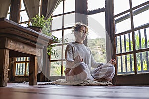 Alone middle age woman at home doing yoga lotus potision as daily routine healthy mental exercise for better body and wellbeing.