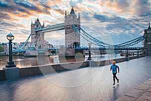 Alone runner in empty streets of london in Coronavirus, Covid-19 quarantine time. Tower Bridge in background