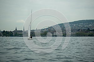 Alone sailboat on the Limmat river on Zurich downtown and cloudy sky background